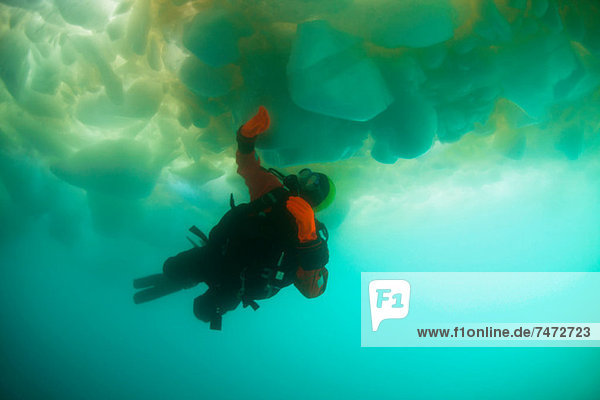 Man scuba diving under glacier