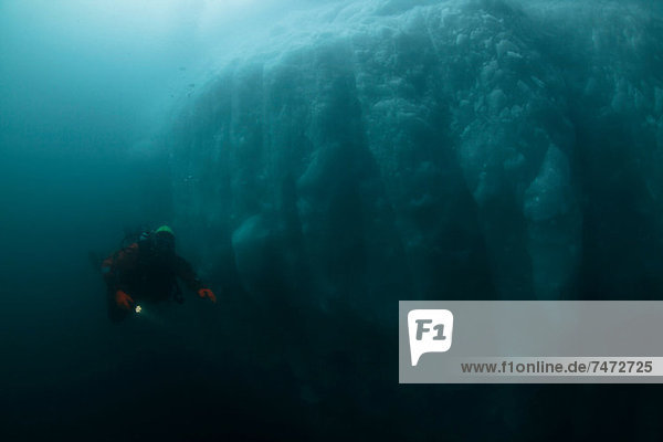 Man scuba diving by glacier