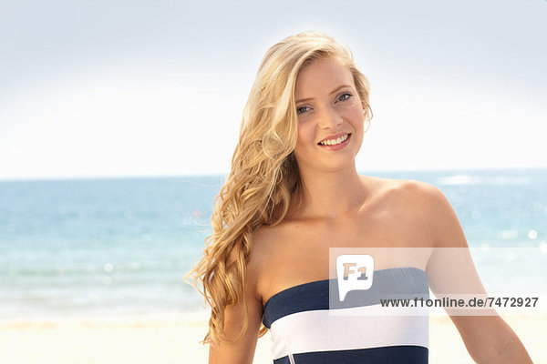 Lächelnde Frau am Strand stehend