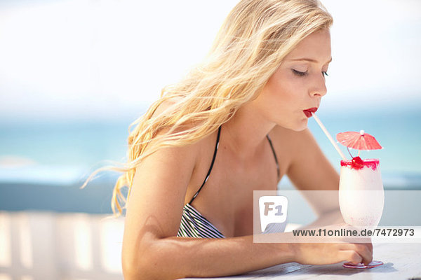 Woman having tropical drink outdoors