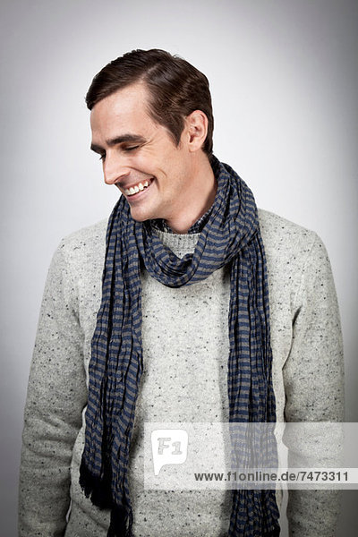 Smiling man wearing scarf indoors