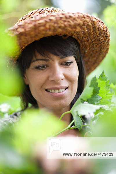 Lächelnde Frau in hohen Pflanzen stehend