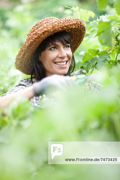 Lächelnde Frau bei der Arbeit im Garten
