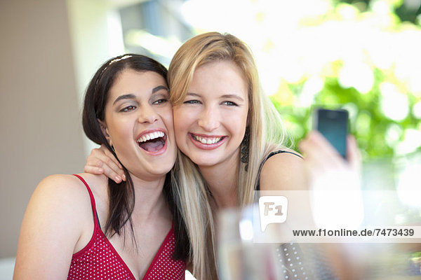Lächelnde Frauen beim gemeinsamen Fotografieren