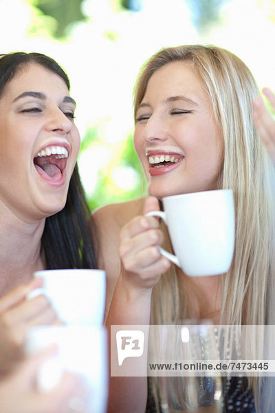 Frauen  die lachen und Kaffee trinken