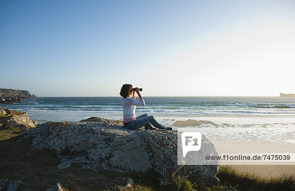 Woman Looking into the Distance Using Binoculars at the Beach  Camaret-sur-Mer  Crozon Peninsula  Finistere  Brittany  France