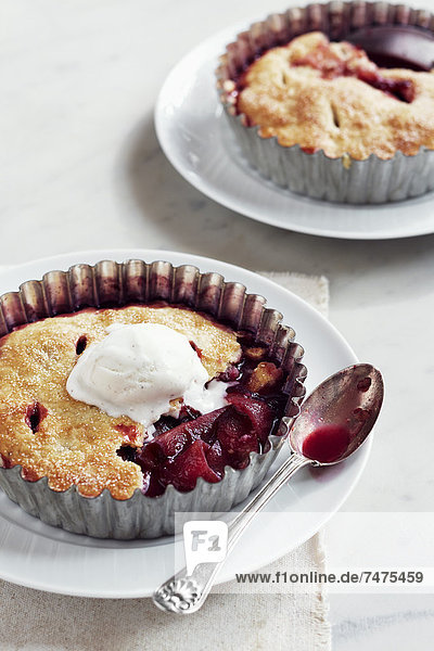 Plum Tarts with Ice Cream on Plates with Spoons