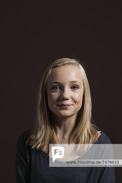 Portrait of Blond  Teenage Girl  Smiling at Camera  Studio Shot on Black Background