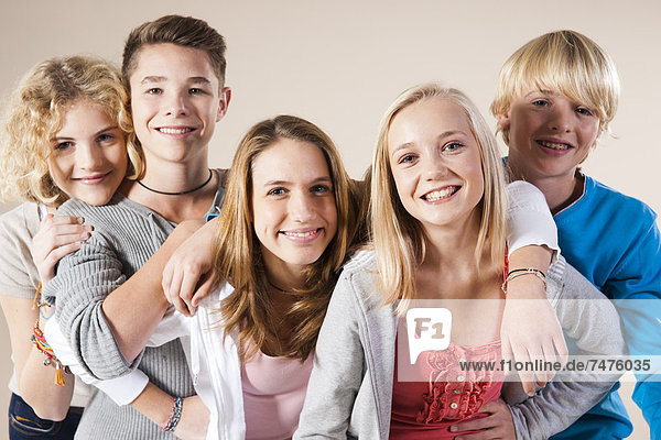 Portrait of Group of Teenage Boys and Girls Smiling at Camera  Studio Shot on White Background