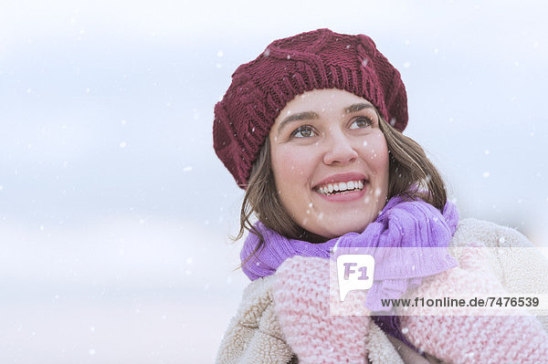 Portrait of young woman wearing knit hat  gloves and scarf