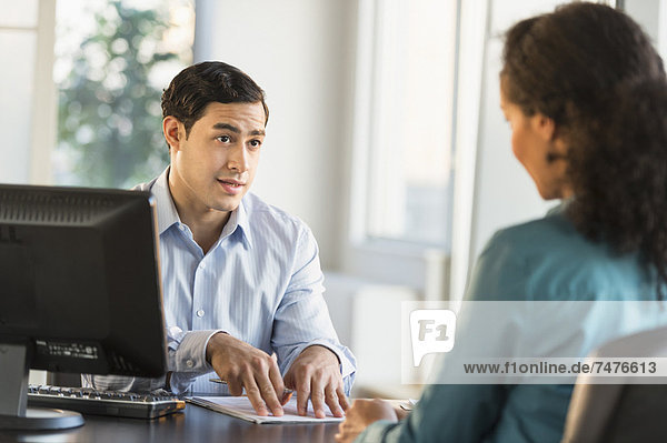 Man and woman talking at desk during job interview