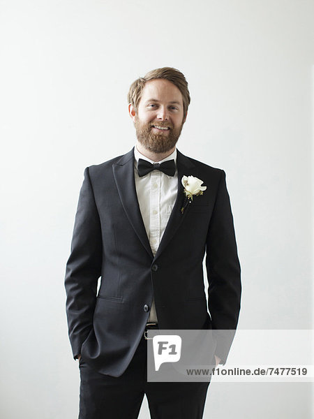 Studio Shot portrait of smiling groom with hands in pockets