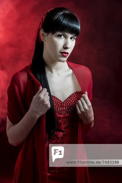 Junge Frau mit langen schwarzen Haaren in rotem Kleid