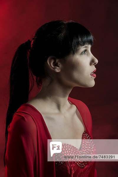 Junge Frau mit langen schwarzen Haaren in rotem Kleid  Portrait