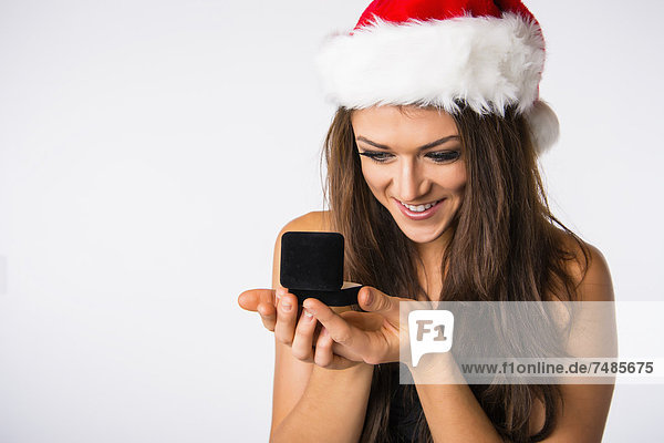 Junge Frau mit Weihnachtsmütze  Blick auf Schmuckkästchen