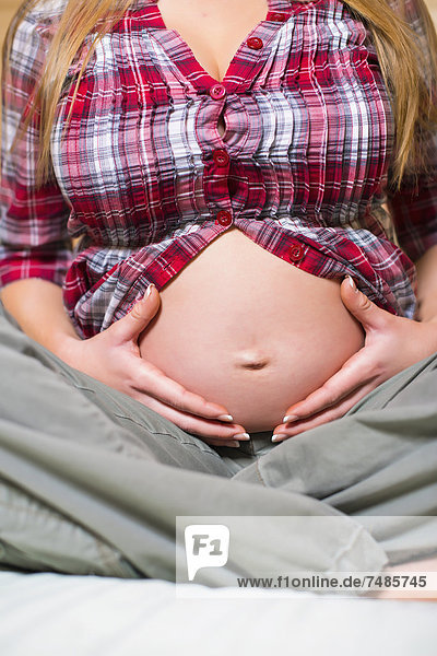 USA  Texas  Schwangere junge Frau  die den Bauch hält