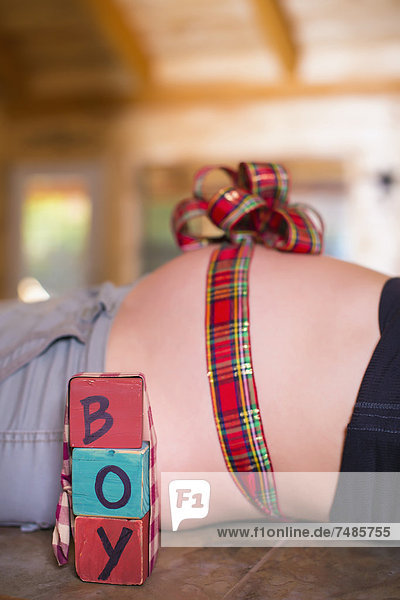 USA  Texas  Schleife in einer Schleife um den schwangeren Bauch gebunden mit Buchstabenblöcken