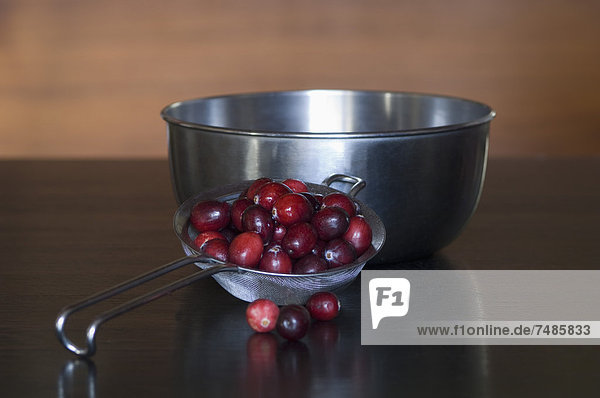 Cranberries im Sieb mit Schale auf dem Tisch