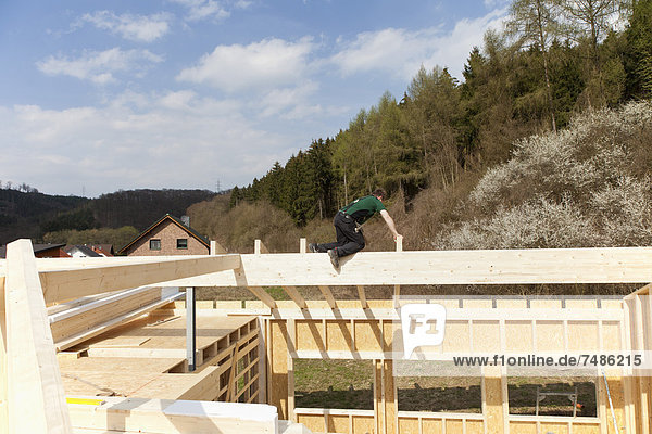 Europa  Deutschland  Rheinland-Pfalz  Mann montiert und befestigt Holzwände von Fertighäusern