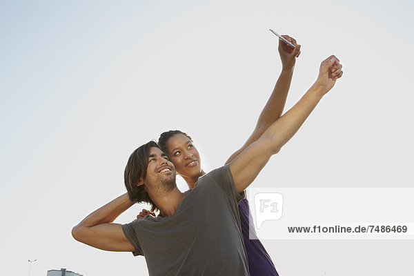 Germany  Cologne  Couple taking self photograph with mobile  smiling