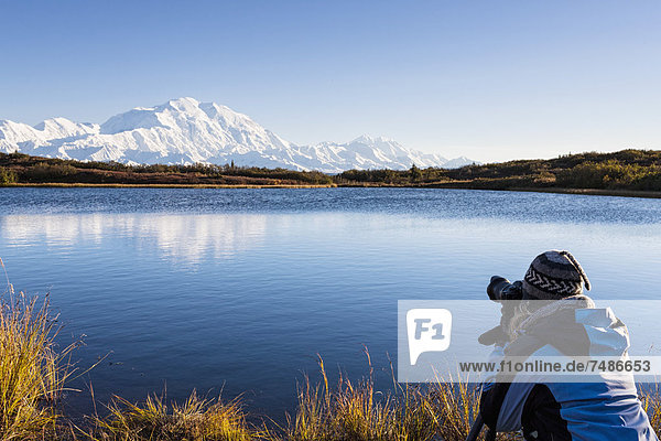 USA  Alaska  Reife Frau beim Fotografieren des Mount Mckinley im Denali Nationalpark