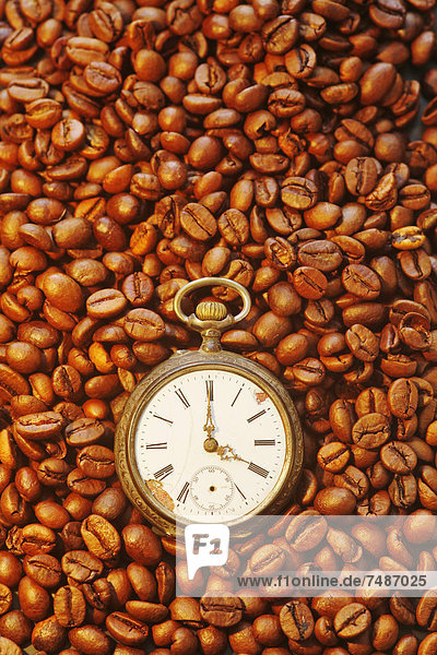 Deutschland  Kaffeebohnen mit antiker Uhr  Nahaufnahme