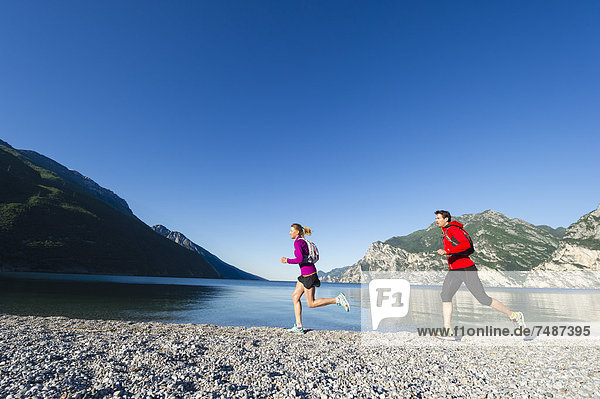 Italy  Mid adult couple jogging by Lake Garda