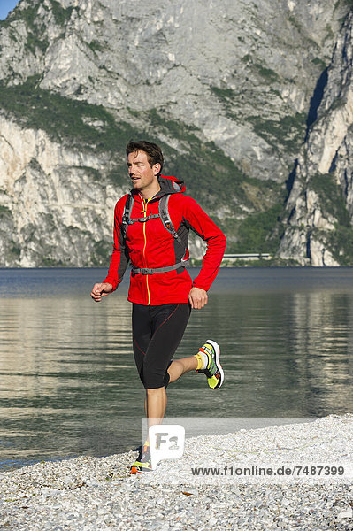 Italy  Mid adult man jogging by Lake Garda