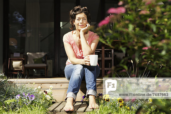 Mature woman relaxing on terrace  smiling  portrait