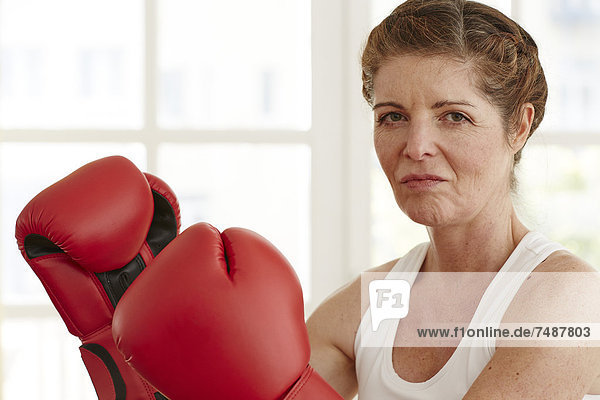 Portrait einer reifen Frau mit Boxhandschuhen