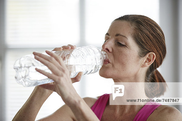 Reife Frau trinkt Wasser nach dem Sport