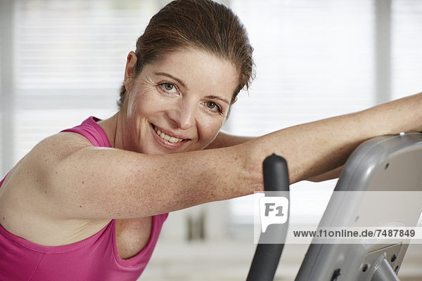 Reife Frau trainiert mit Laufband  lächelndes Portrait
