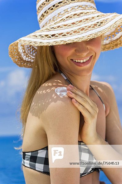 Frau trägt Sonnenschutz auf