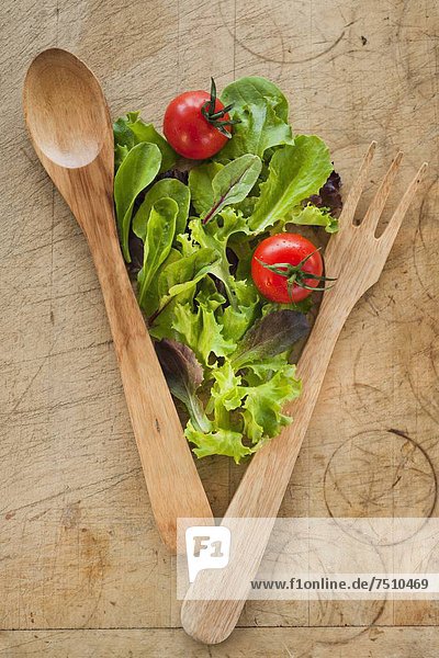 Salad leaves and wooden spoon and fork