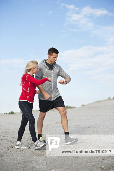 Junge Jogger beim Auschecken am Strand
