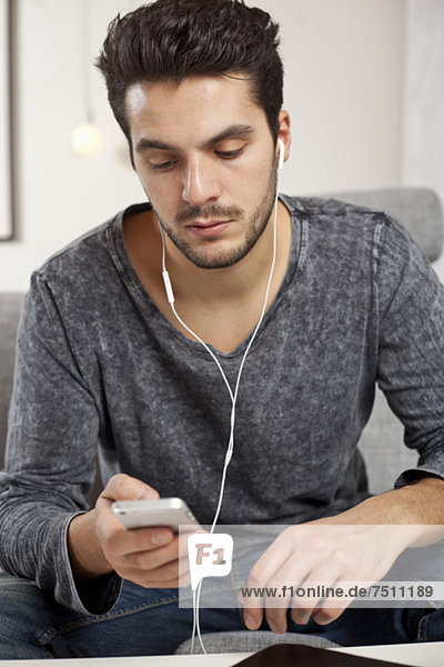 Junger Mann hört Musik über Handy