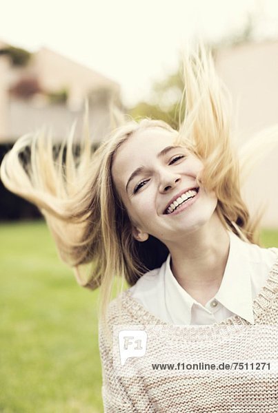 Porträt eines fröhlichen jungen Mädchens  das Haare wirft.