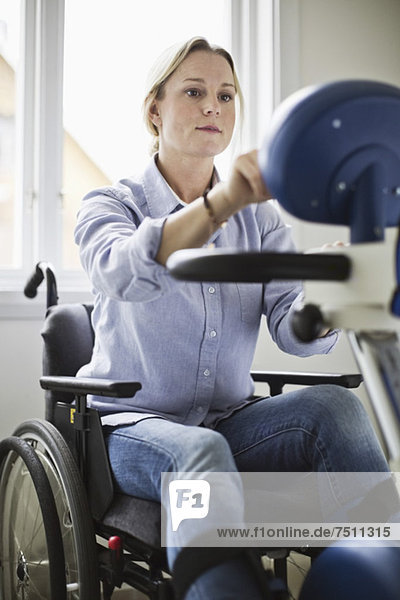 Behinderte Frau im Rollstuhl mit motorisiertem Fahrrad