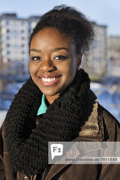 Porträt einer fröhlichen jungen Afroamerikanerin  die im Freien lächelt.