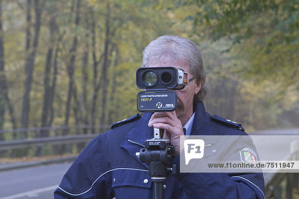 Polizist mit Radarpistole  beim Blitzermarathon der Polizei im Oberbergischen Kreis am 24.10.2012  Geschwindigkeitsüberwachung  Lindlar  Nordrhein-Westfalen  Deutschland  Europa