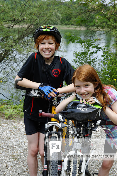 Two children  boy and girl  with mountain bikes and helmets