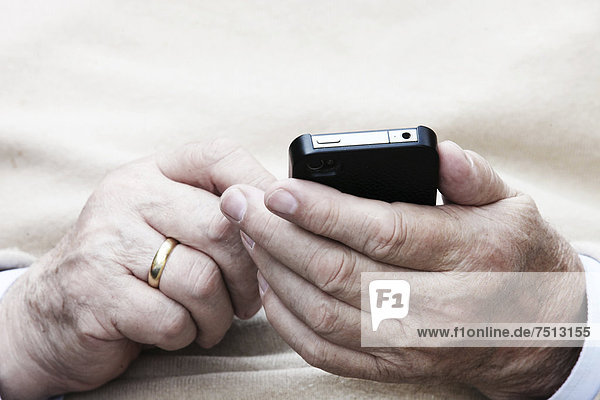 Elderly man holding a smartphone in his hand