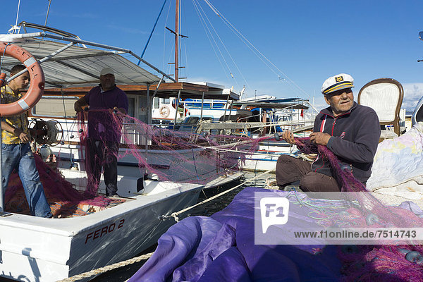 Zeytineli Köyü  Hafen mit Fischerbooten  Fischer reparieren ein Netz  Ilica  Region Izmir  Türkei  Asien