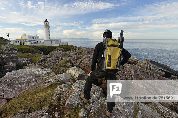 Hiker with a backpack in front of Rua Reidh Lighthouse  Melvaig  Gairloch  Western Ross  Scotland  United Kingdom  Europe