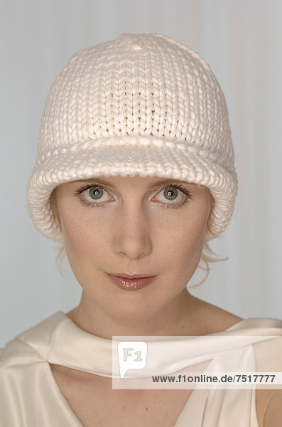 Blonde Frau mit weißer Wollmütze  Portrait