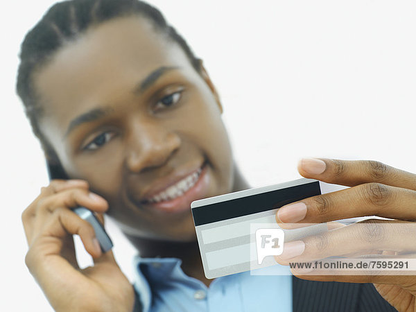 Businessman  African American  talking on a telephone and holding a credit card