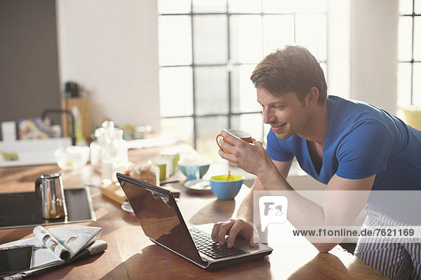 Mann mit Laptop und Tasse Kaffee