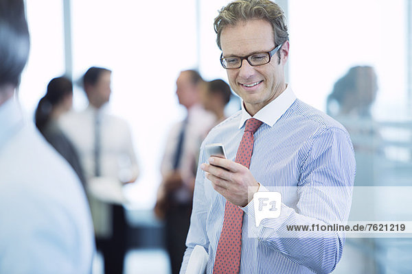 Businessman using cell phone in office