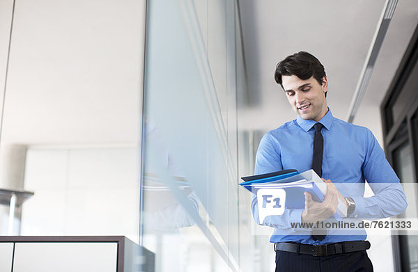 Businessman using digital tablet in office hallway