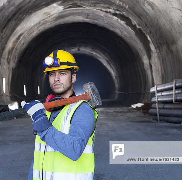 Arbeiter mit Vorschlaghammer im Tunnel